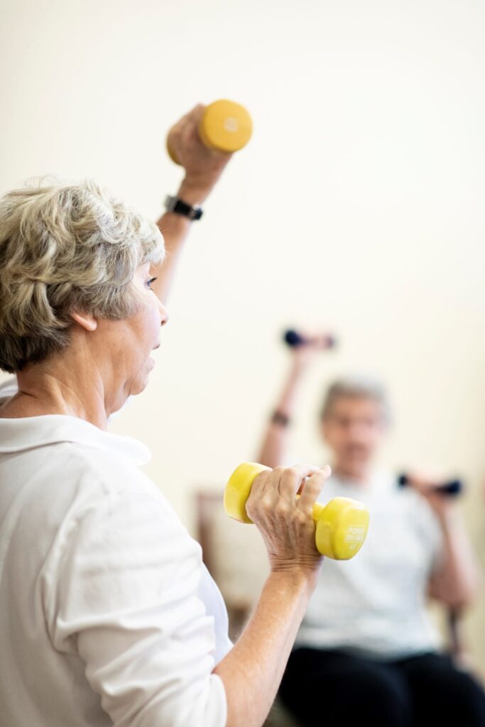 Senior woman lifting hand weights in exercise class