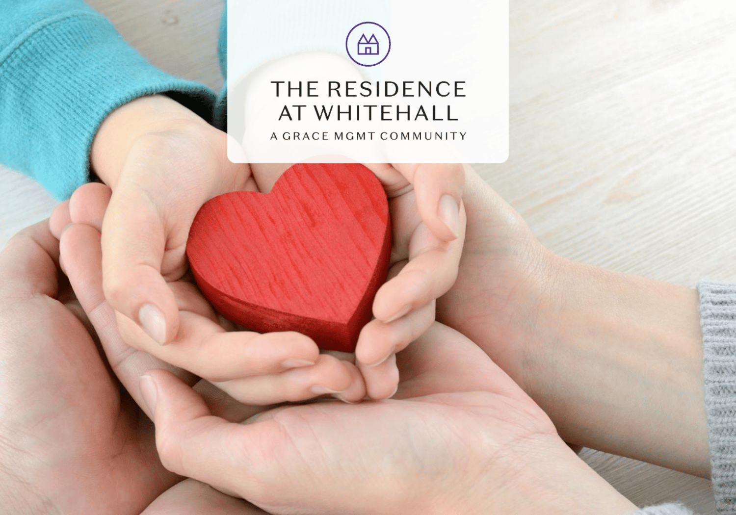 Hands cupping a red wooden heart, symbolizing care and compassion.